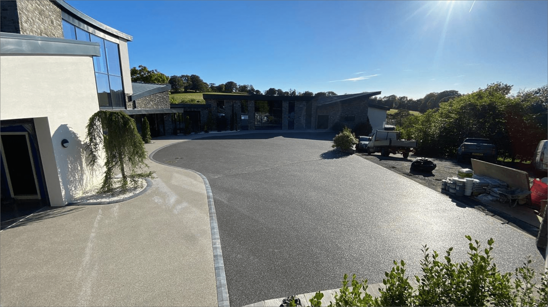 Large resin driveway outside house, clear blue sky